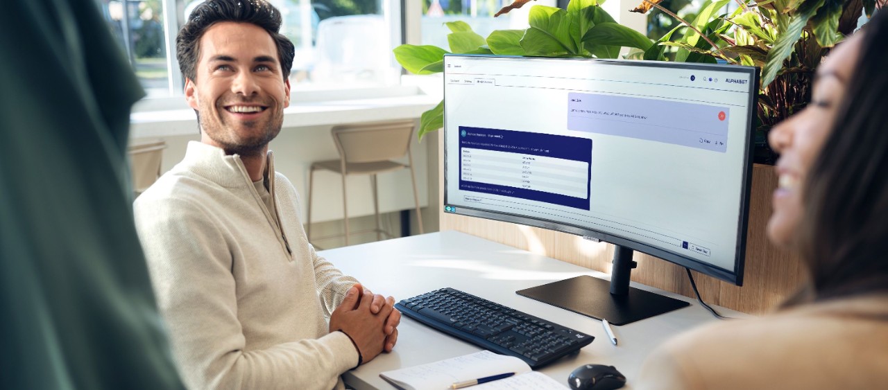 Man lacht vanaf zijn werkplek met zijn collega's