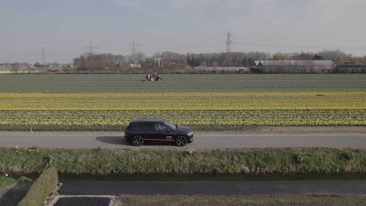 Een zwarte BMW iX op een polderweg.
