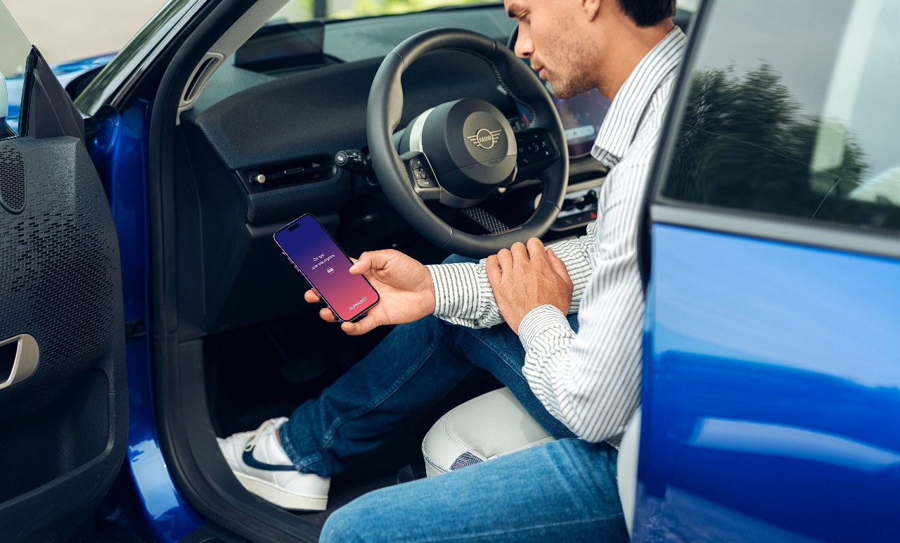 Man kijkt in de auto op zijn telefoon