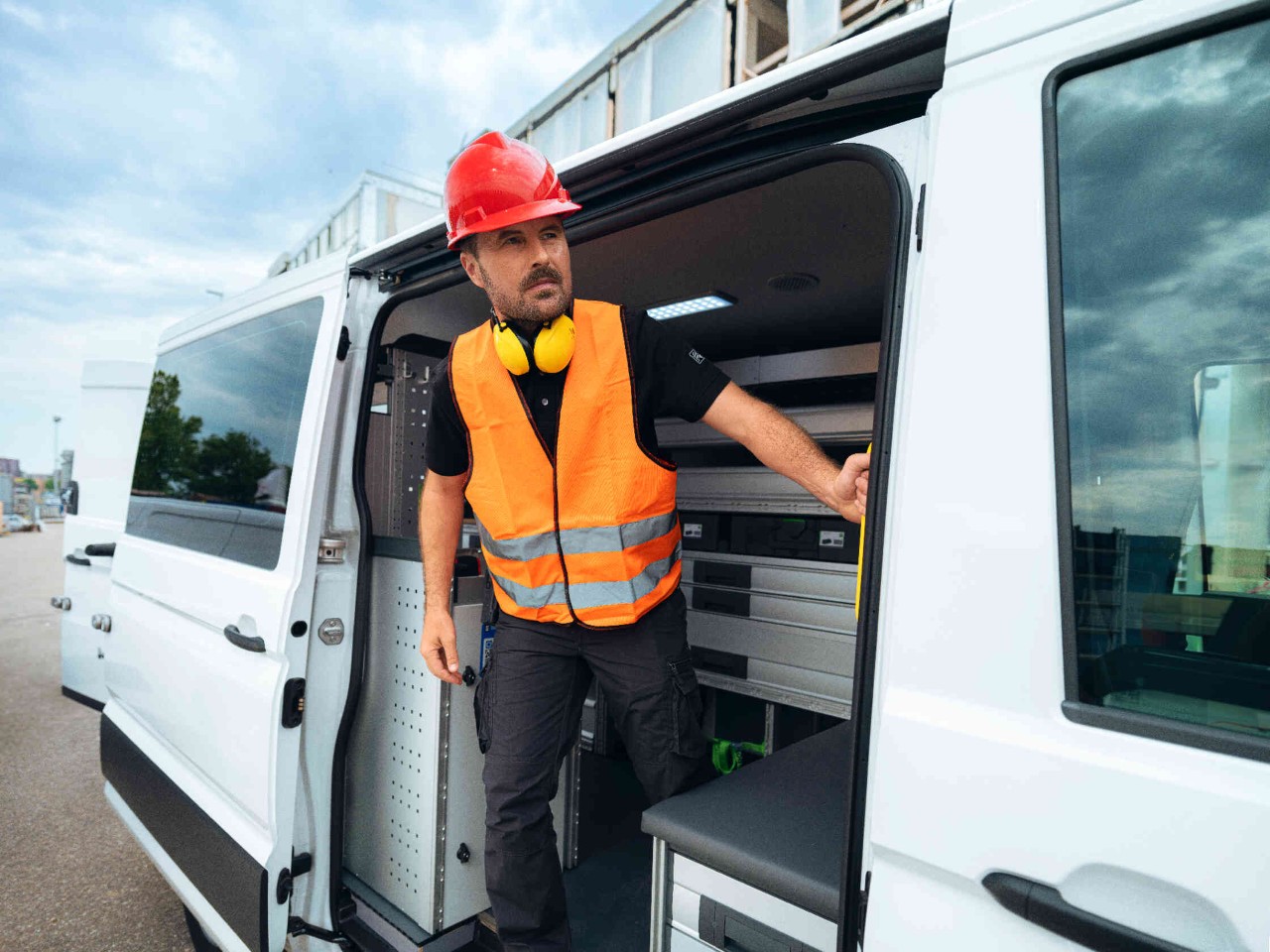 Man staat in de opening van zijn busje