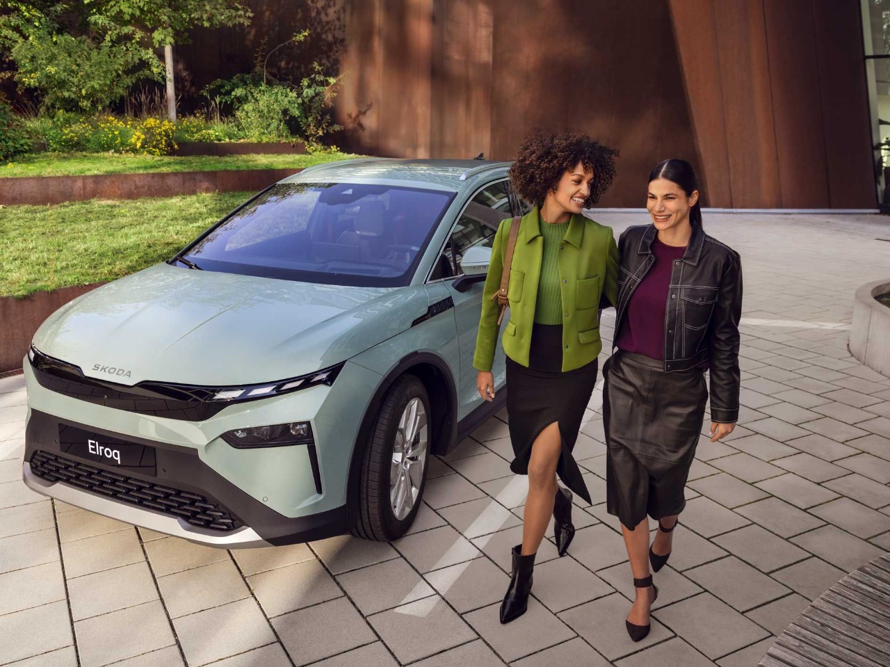 Twee vrouwen lopen langs een Skoda.
