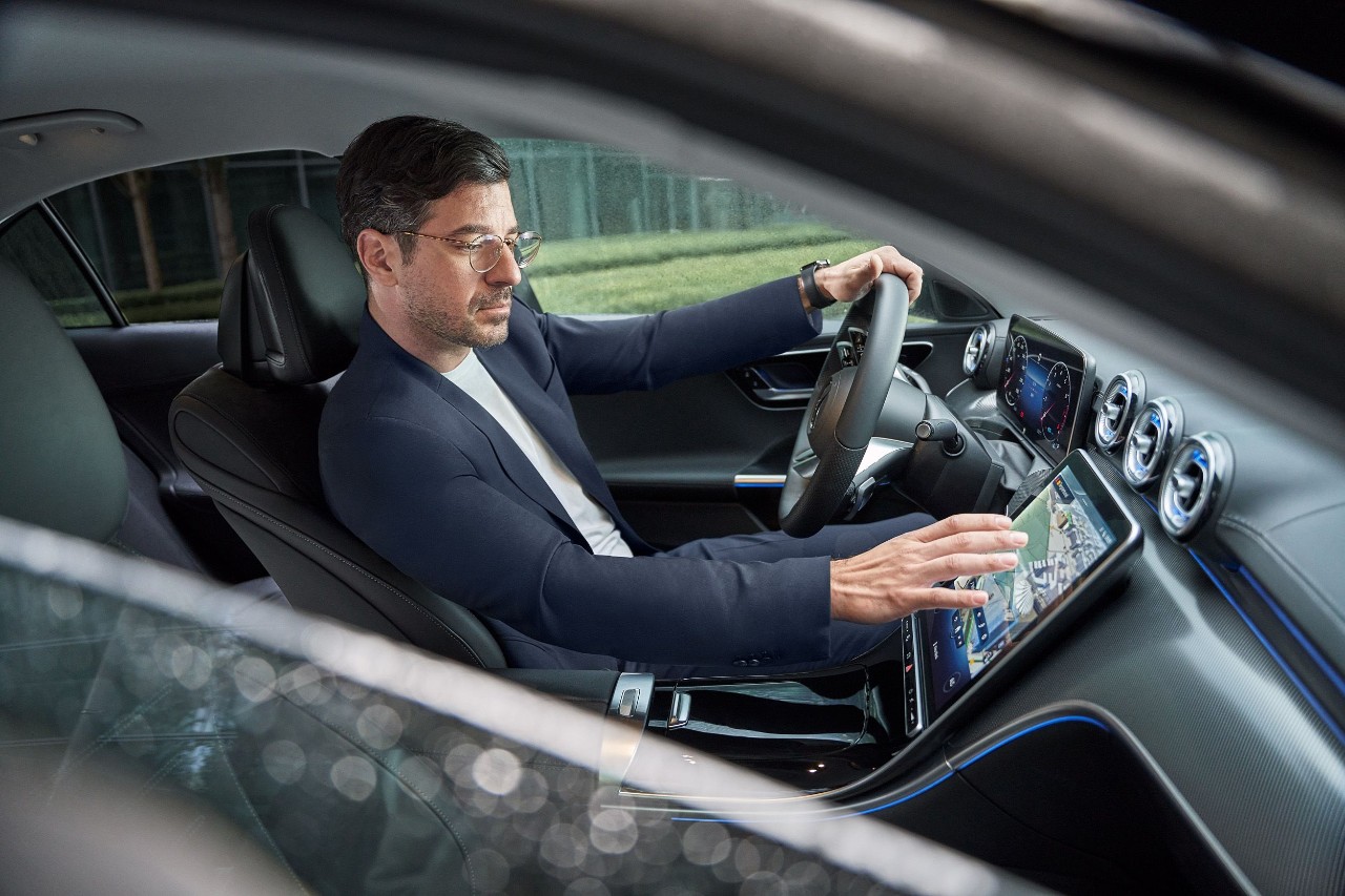 Man in een luxe auto bedient zijn navigatie.
