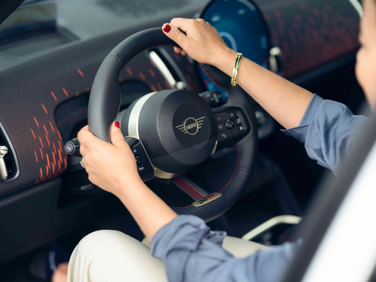 Vrouw zit achter het stuur van een MINI-auto.