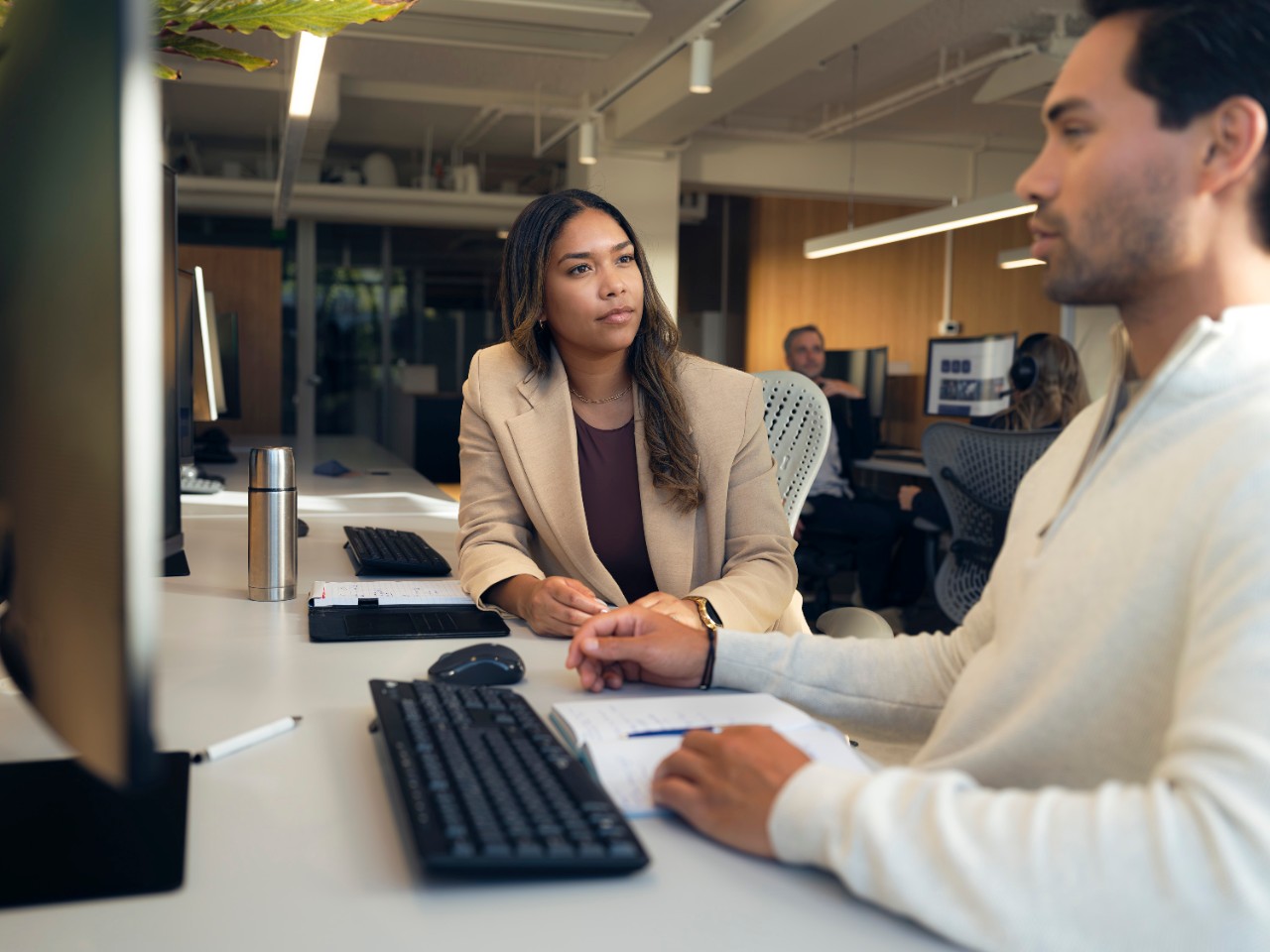 Mann sitzt auf Fahrersitz eines stehendes Autos schaut auf sein Handy Fahrertuer steht offen.